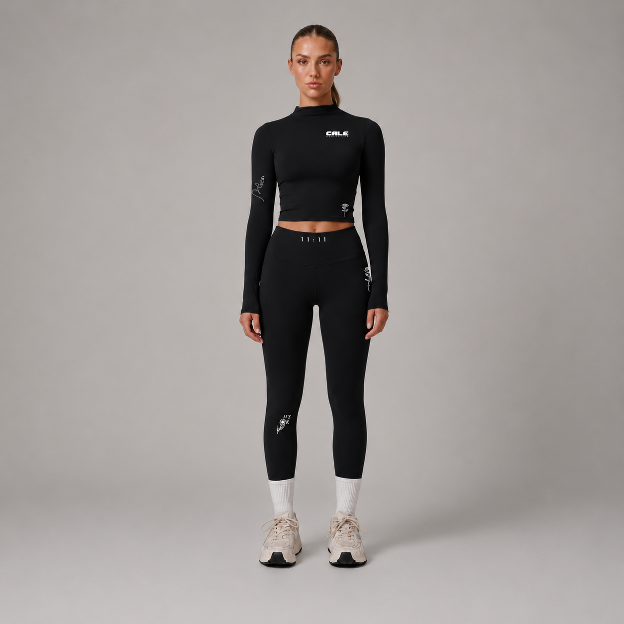 Black fitted long sleeve crop top worn with matching black leggings and sneakers, showcasing a smooth texture and snug fit.