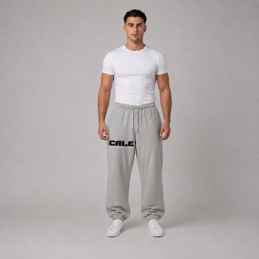 Light grey oversized track pants with elastic waistband and drawcord, styled with a fitted white t-shirt.