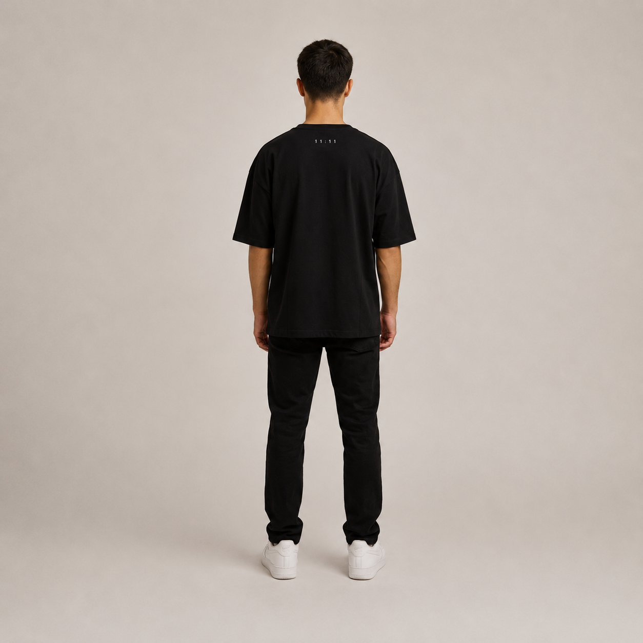 Black oversized graphic t-shirt on a model wearing black pants, showcasing a relaxed fit and loose silhouette.