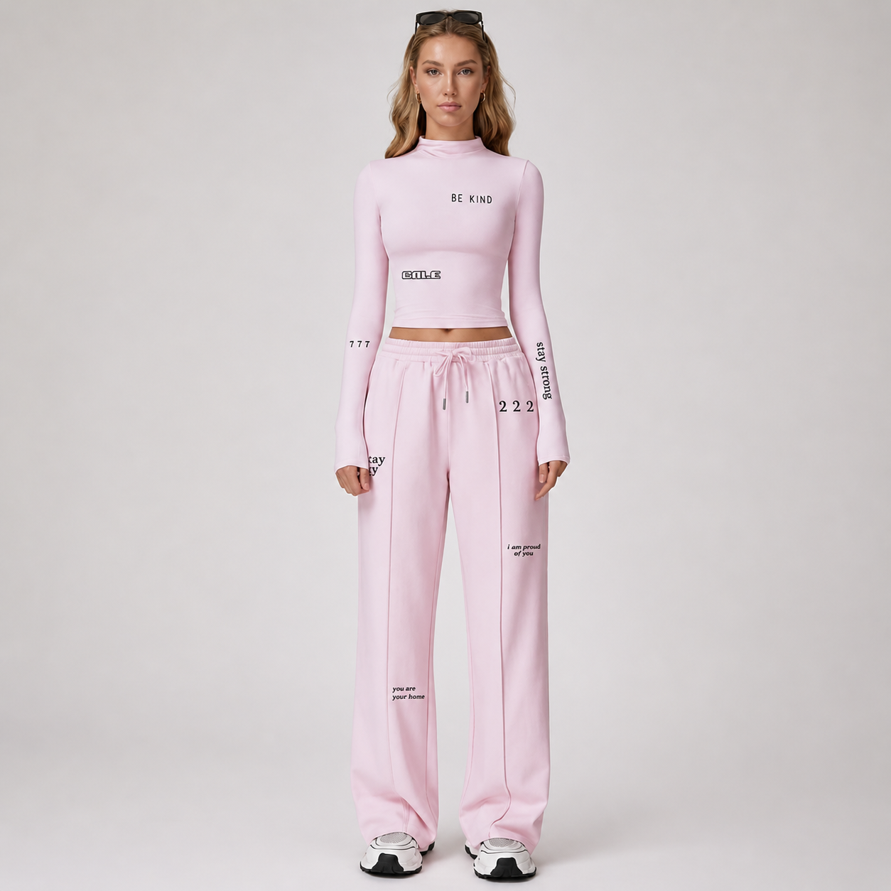 Pink fitted long sleeve crop top with high neckline, styled casually with matching pink pants.
