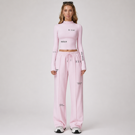 Pink fitted long sleeve crop top with high neckline, styled casually with matching pink pants.