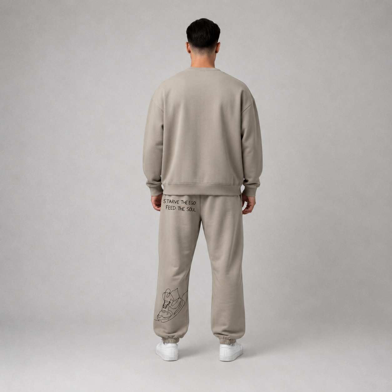 Person wearing a stone oversized crew sweatshirt with streetwear-inspired graphics, showcasing a relaxed fit.