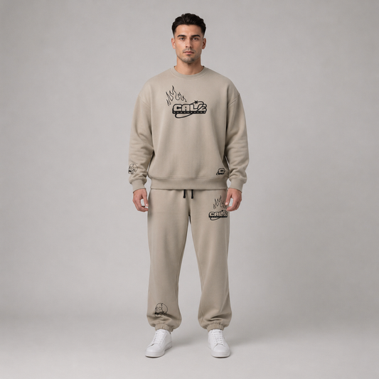 Model wearing a stone oversized crew sweatshirt with streetwear graphics, styled with matching pants and white sneakers.