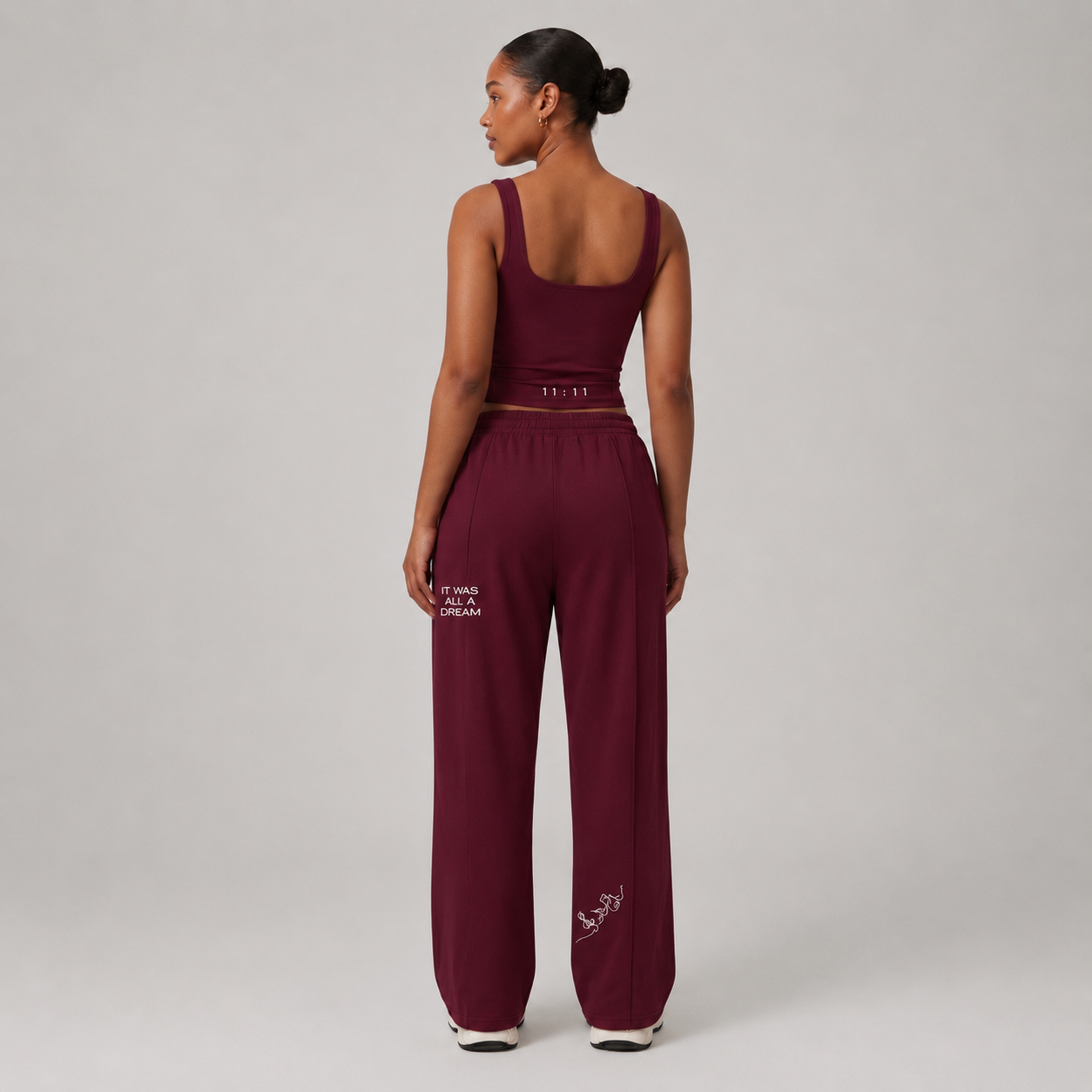 Burgundy fitted tank top with scoop neckline and wide straps, styled with matching burgundy pants.