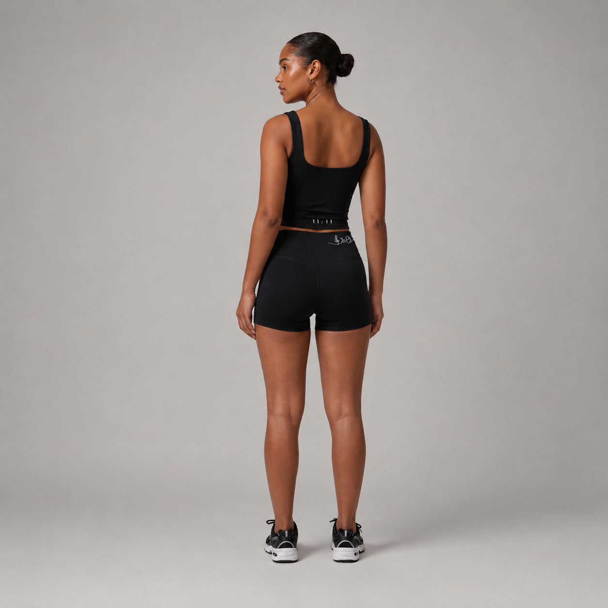 Black shorts with a fitted shape and side pockets, styled with a black top against a neutral background.
